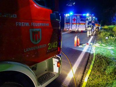 Das Löschfahrzeug 2/42 und ein Rettungswagen stehen auf der Bundesstraße.