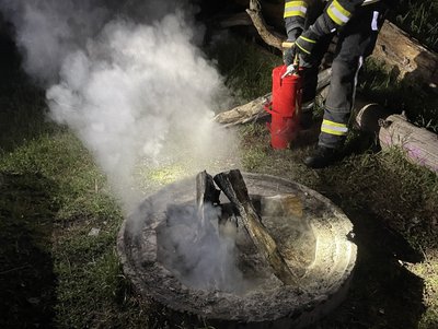 Zu sehen ist ein Angehöriger der Feuerwehr wie er den Kleinbrand löscht.