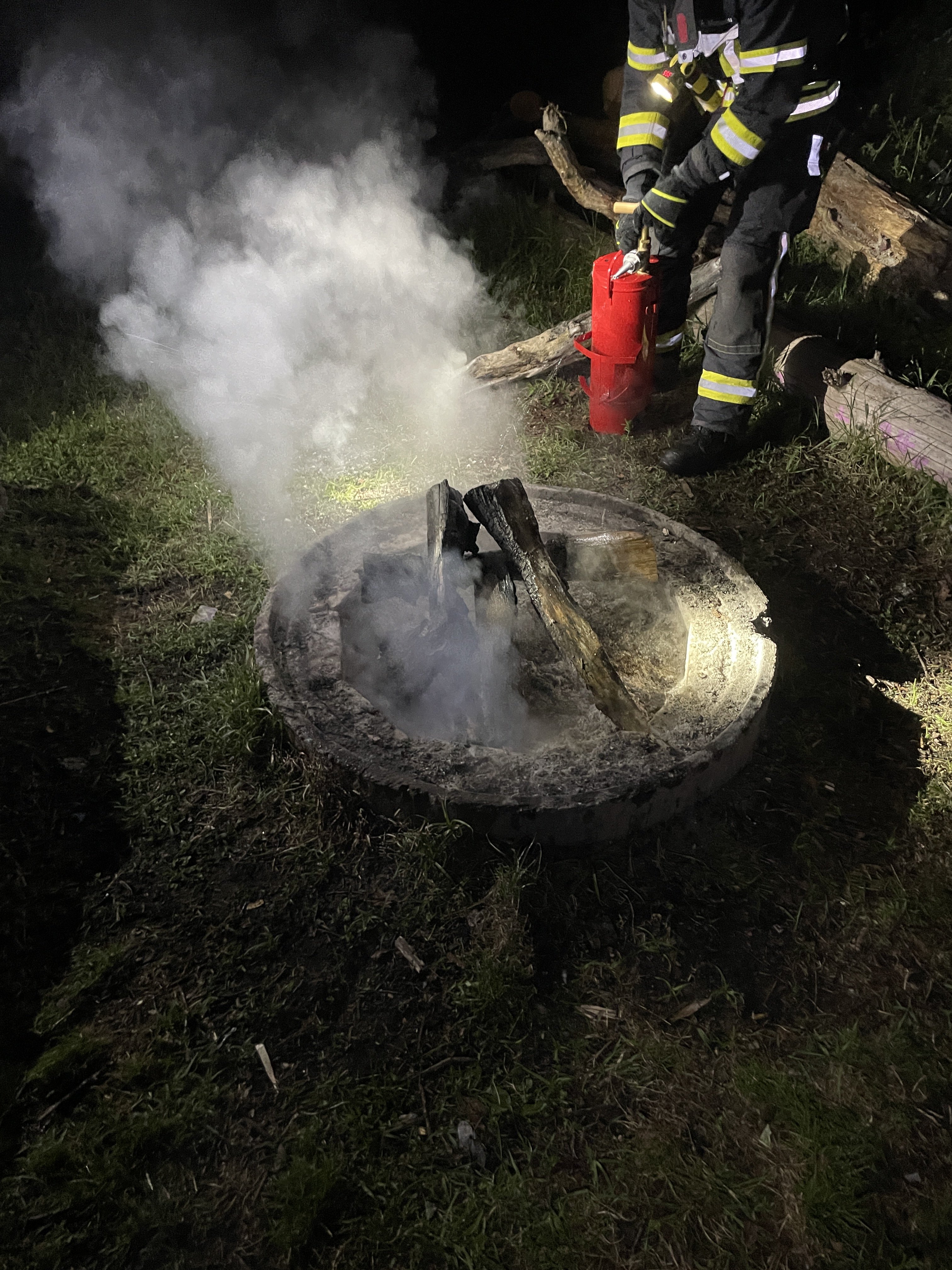 Zu sehen ist ein Angehöriger der Feuerwehr wie er den Kleinbrand löscht.