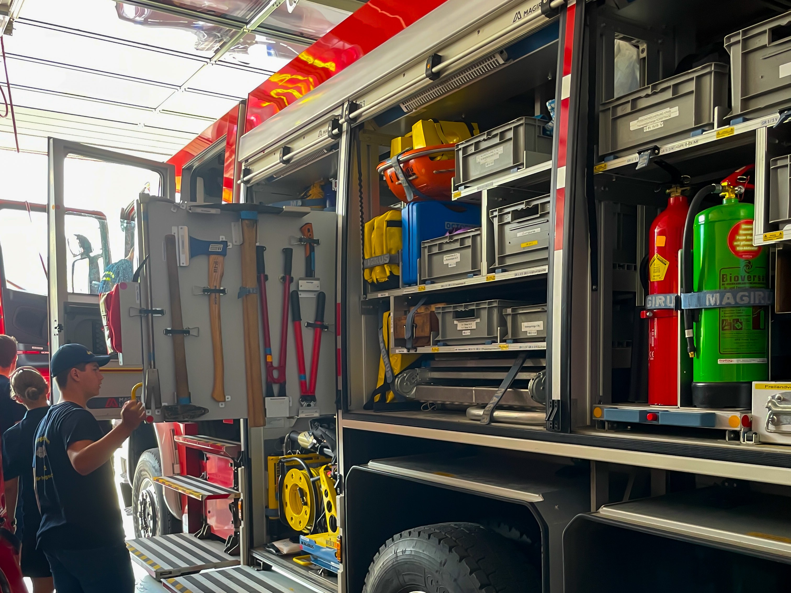 Zu sehen ist wie die Teilnehmer die Fahrzeuge der Feuerwehr Egg erkunden.