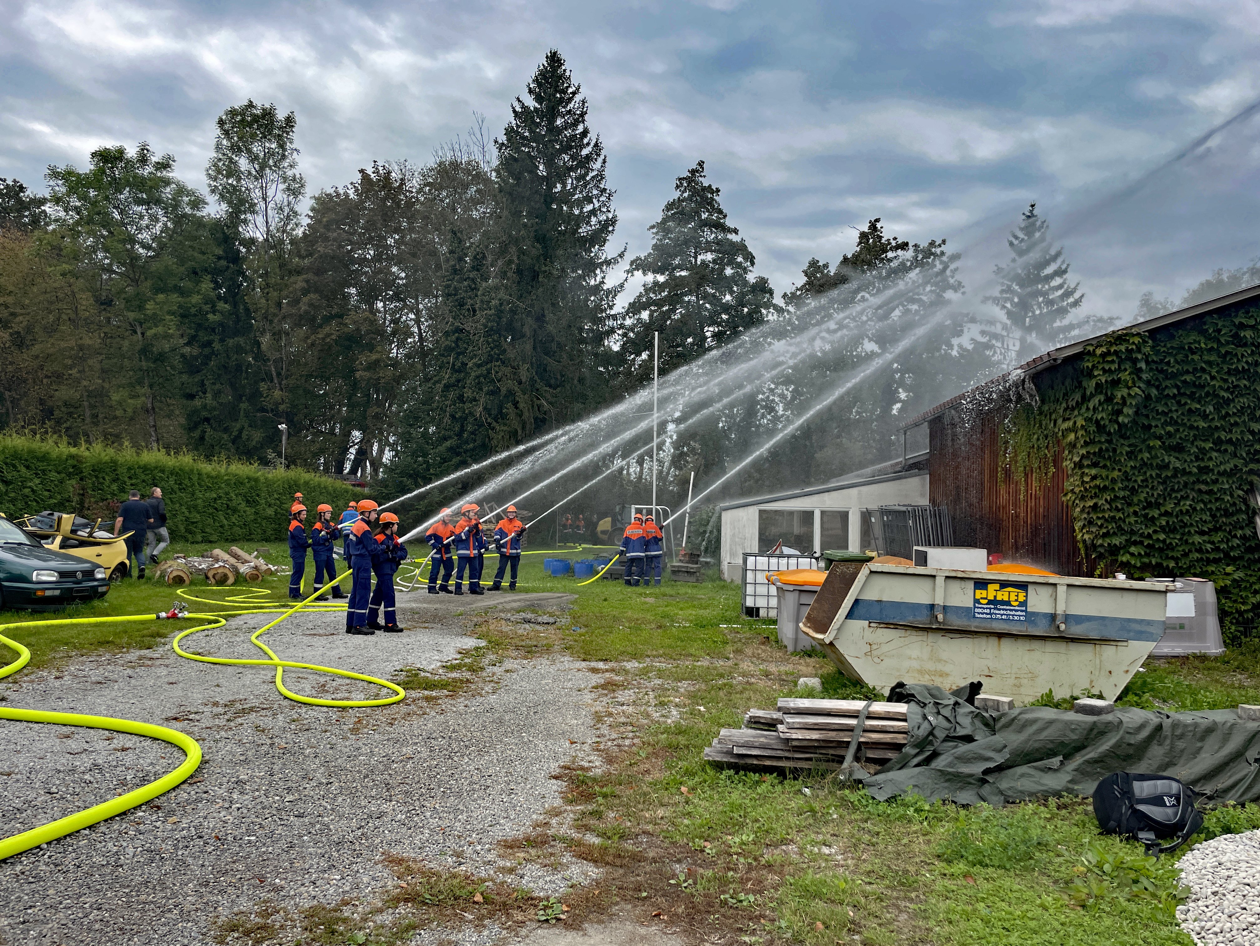 Zu sehen sind die Teilnehmer der Übung beim Löschen eines fiktiven Brandes.