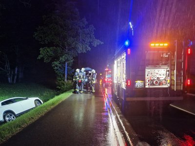 Ein PKW liegt im Straßengraben. Das Löschfahrzeug 1/42 leuchtet die Unfallstelle aus.