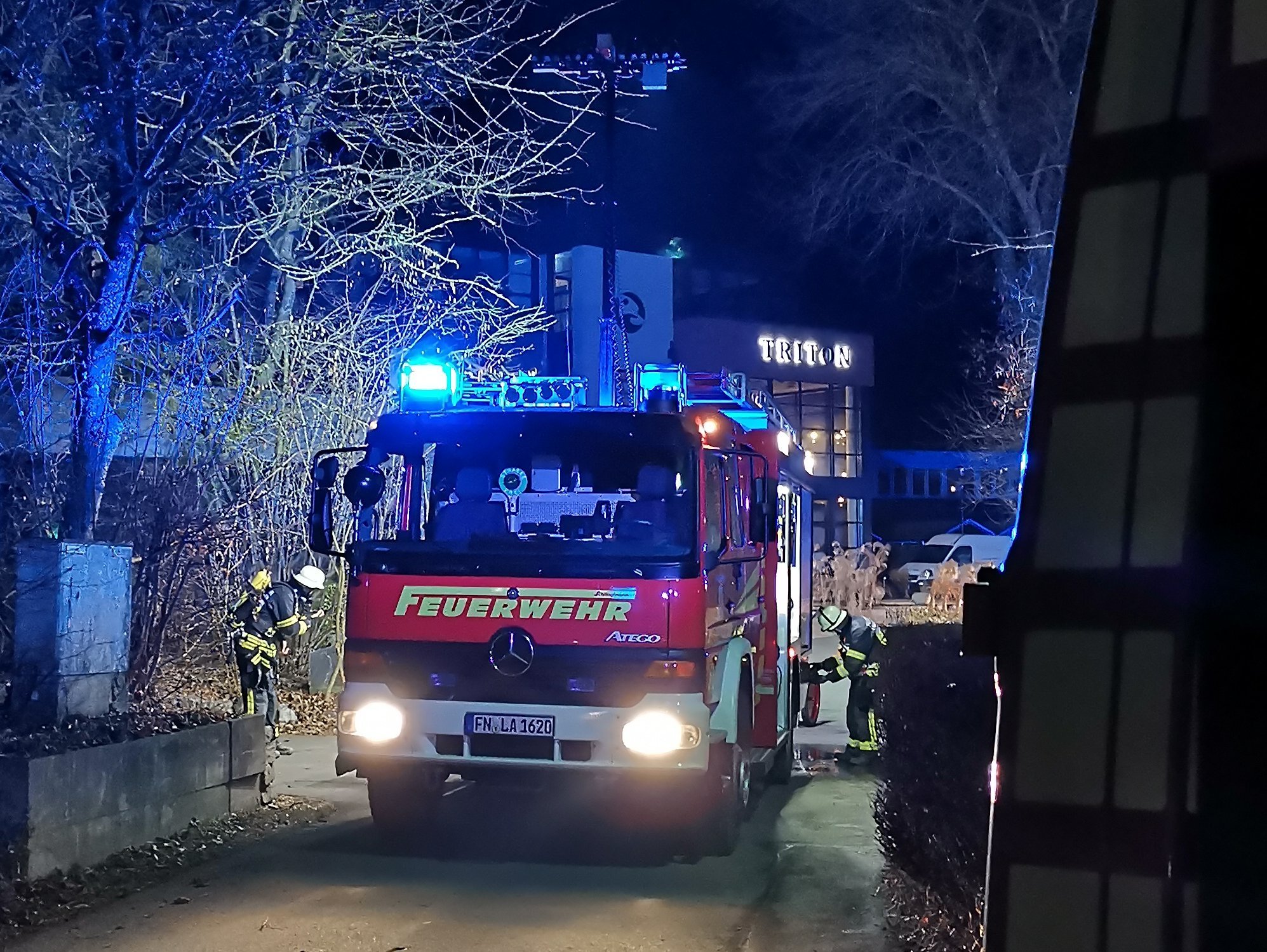 Löschfahrzeug steht mit Blaulicht auf einer Straße.