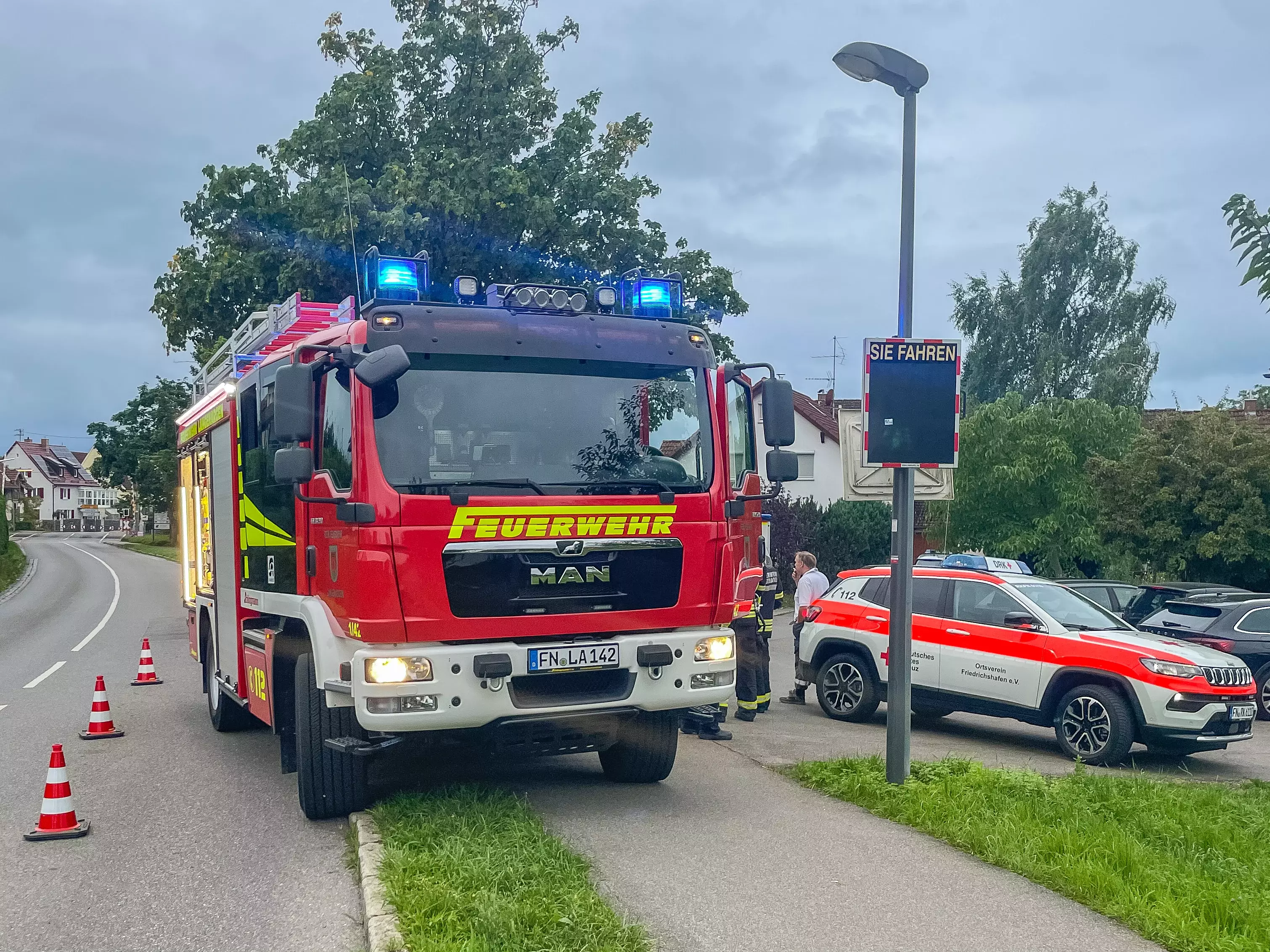 Das Löschfahrzeug 1/42 steht mit Blaulicht am Straßenrand.