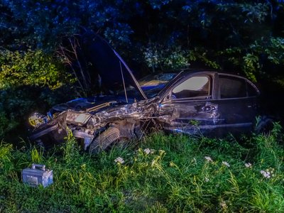 Eines der verunfallten Fahrzeuge ist sichtlich zerstört neben der Straße zu stehen gekommen.