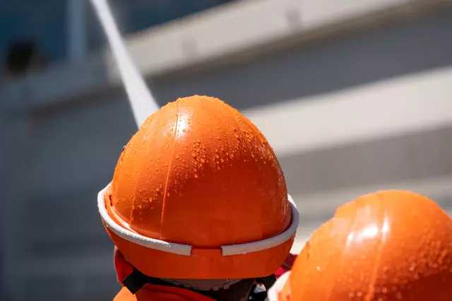 Nahaufnahme der Helme zweier Jugendfeuerwehrler, die gerade dabei sind, zu löschen.