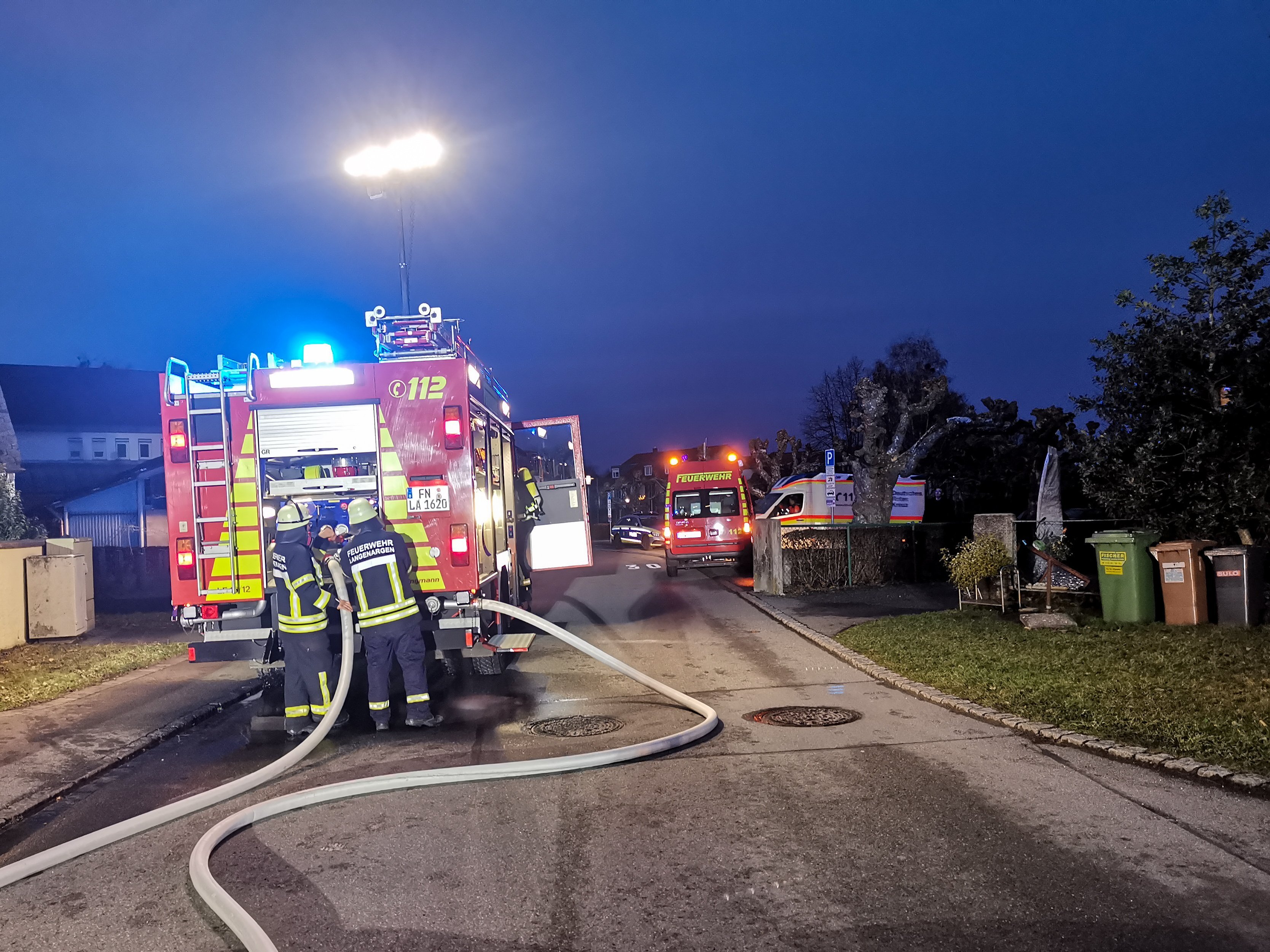 Löschfahrzeug 1/44 steht mit Blaulicht auf der Straße. An der Pumpe sind Schläuche angeschlossen.