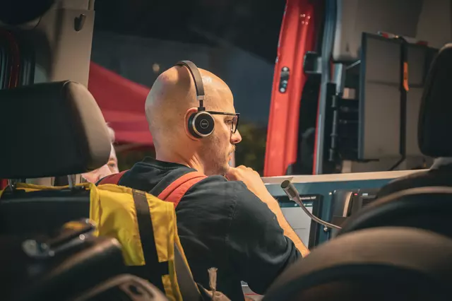 Eine Einsatzkraft der Technik und Sicherheit arbeitet mit einem Headset im Einsatzleitwagen.