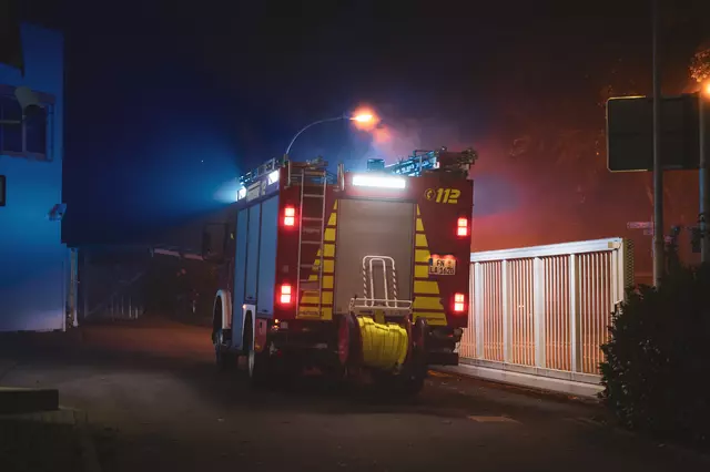 Das Löschfahrzeug 1/44 steht mit Blaulicht in Bereitschaft auf dem Werksgelände.