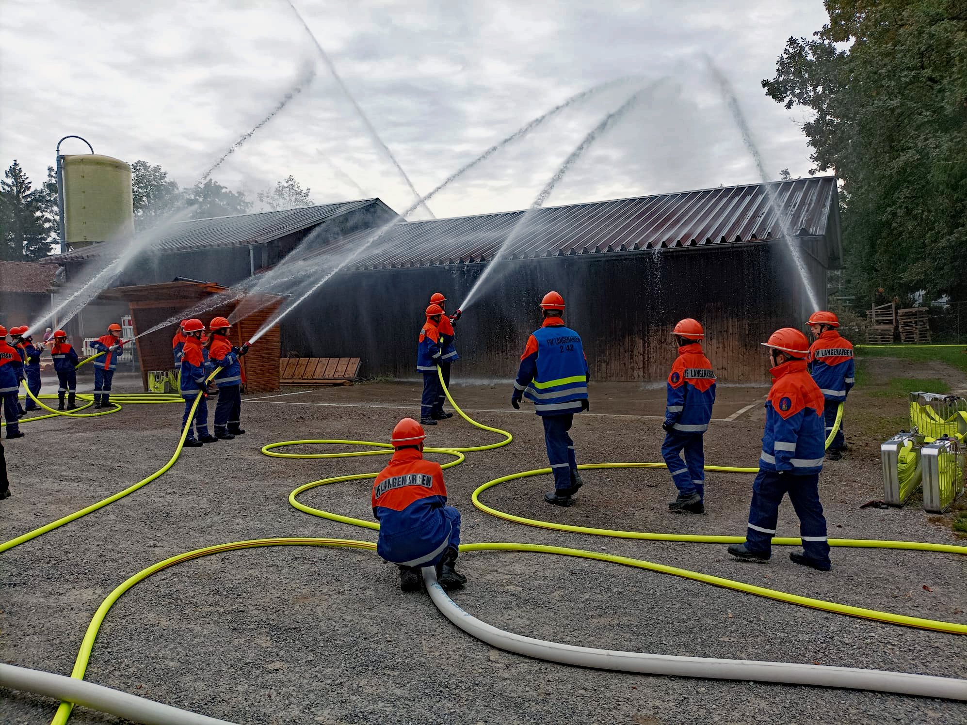 Zu sehen sind die Teilnehmer der Übung beim Löschen eines fiktiven Brandes.