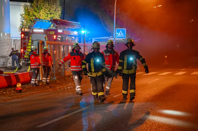 Zwei Feuerwehrmänner und zwei DRK Kräfte tragen einen Verletzten auf der Trage.