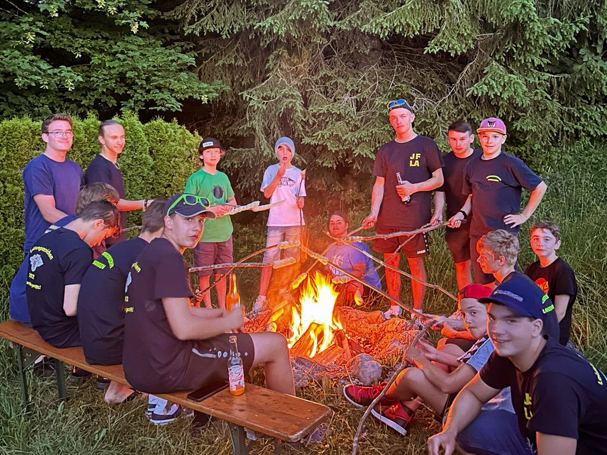 Zu sehen ist wie Stockbrot am Lagerfeuer gemacht wird.