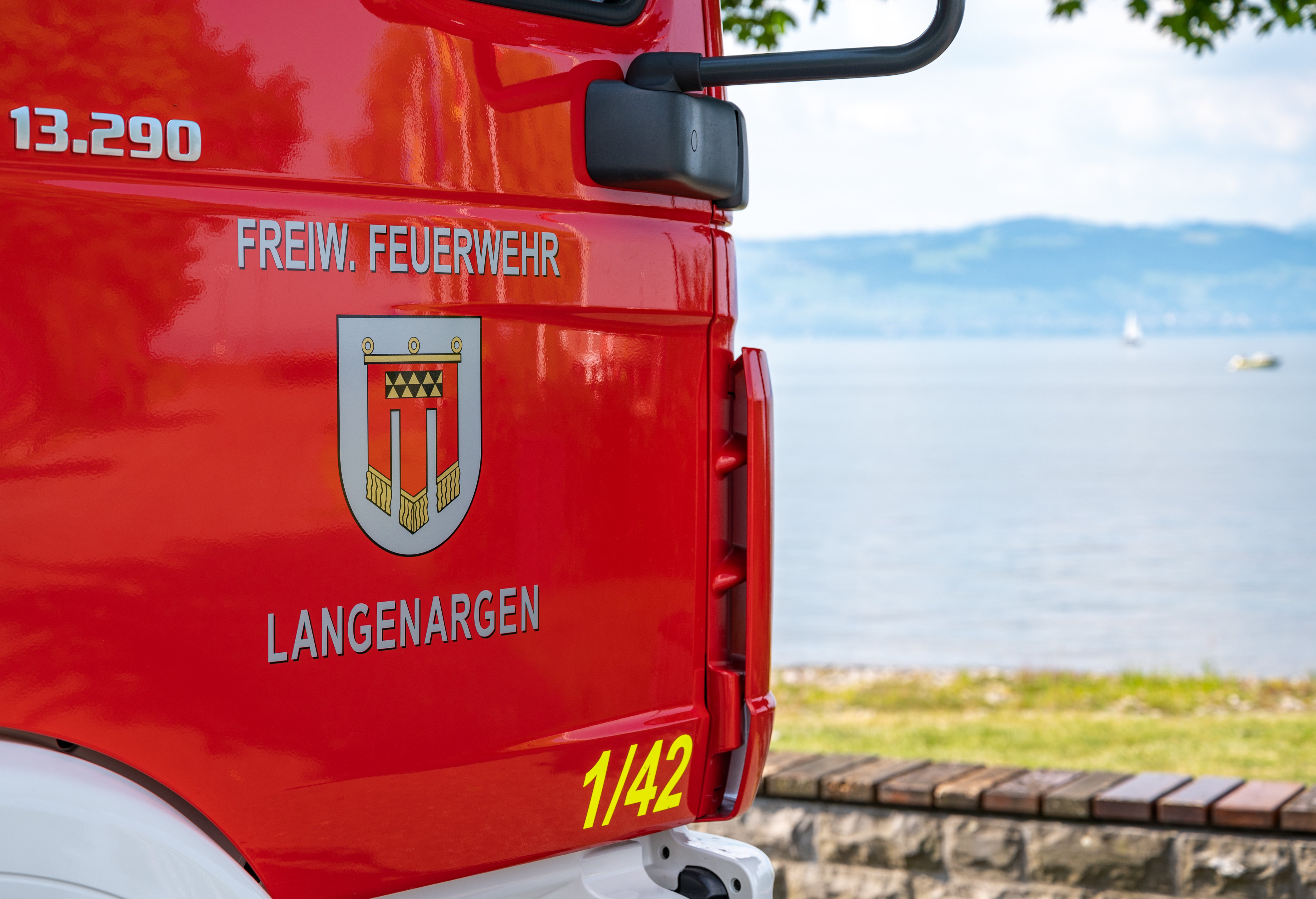 Das Löschfahrzeug 10 steht am Bodenseeufer, das Wappen an der Beifahrertür und der Blick auf den Bodensee sind zu sehen.