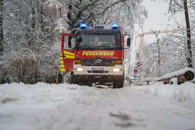 Das Löschfahrzeug 1/44 mit Blaulicht auf der verschneiten Straße.