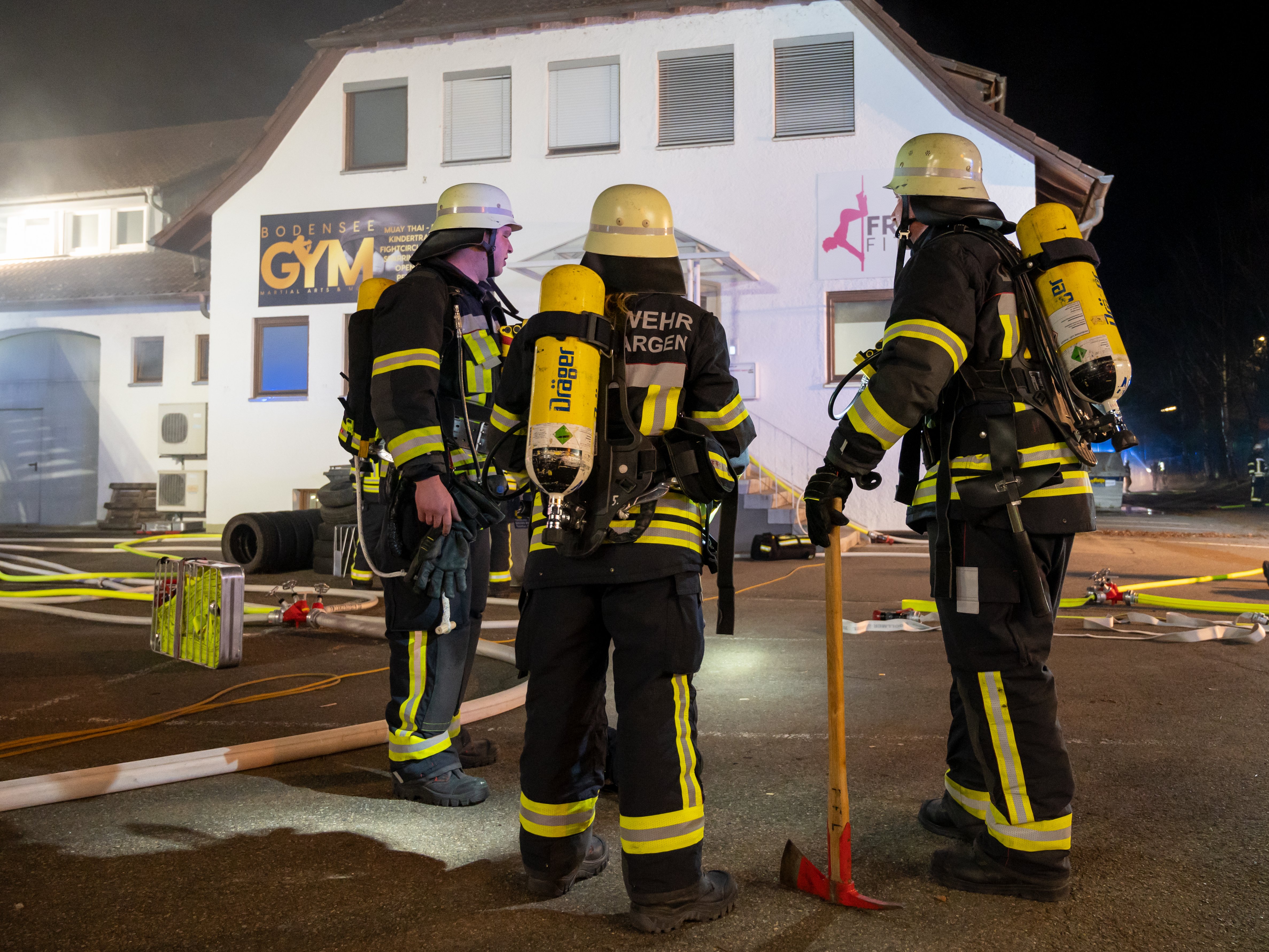 Atemschutzgeräteträger stehen vor einem Gebäude