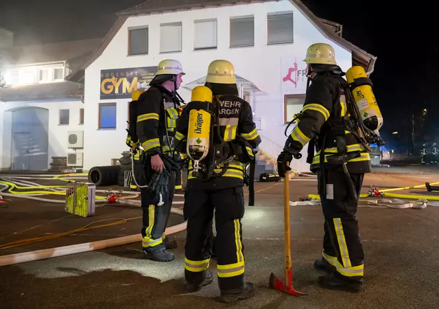 Atemschutzgeräteträger stehen vor einem Gebäude