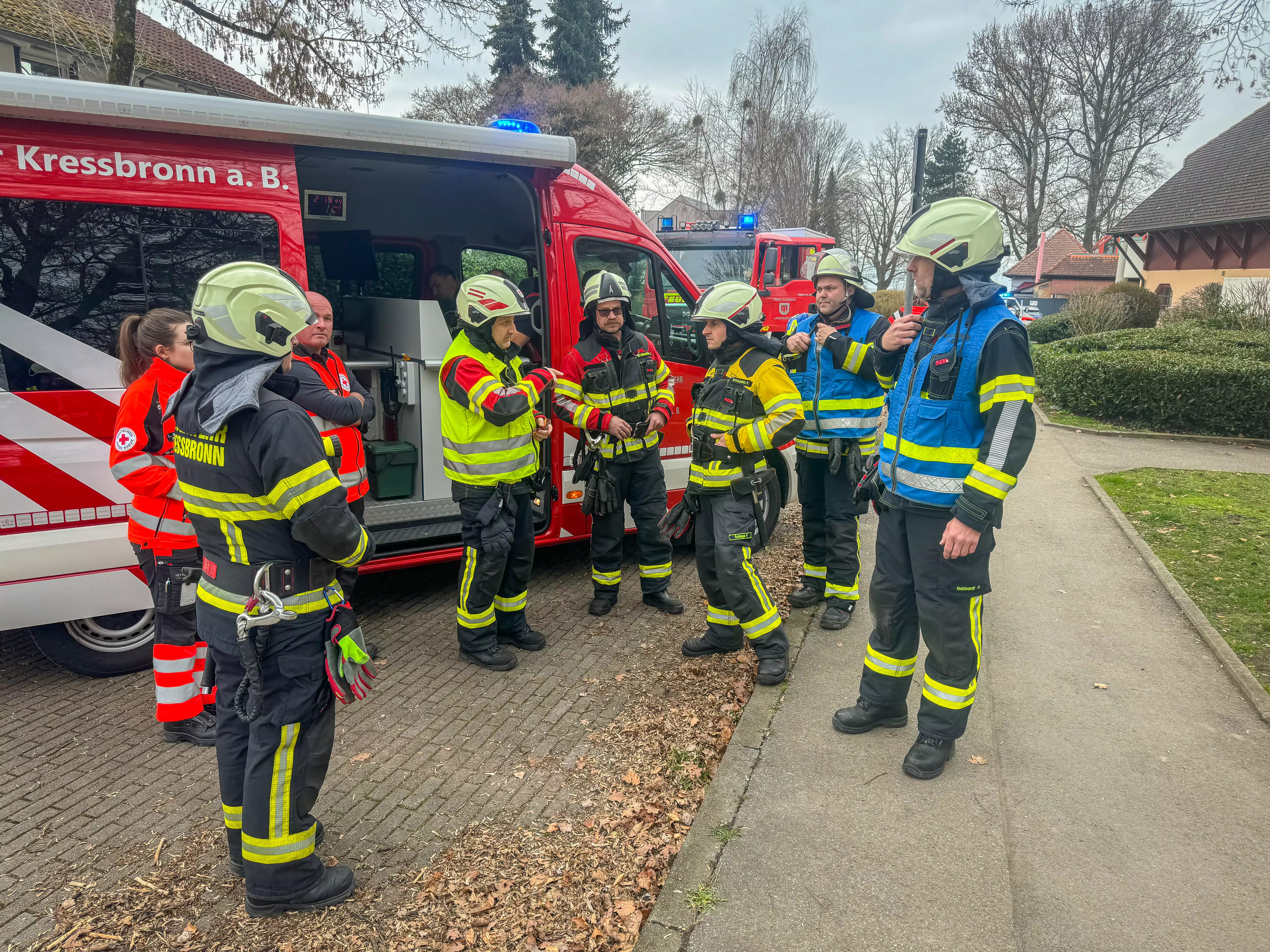 Führungskräfte besprechen sich am Einsatzleitwagen der Feuerwehr Kressbronn