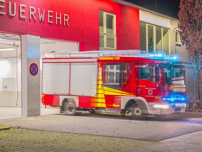 Das Löschfahrzeug 2/42 verlässt das Gerätehaus mit Blaulicht.